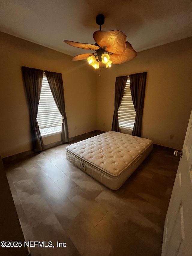 bedroom with ceiling fan and baseboards