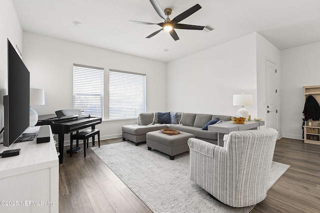 living area featuring dark wood-style floors, visible vents, baseboards, and a ceiling fan