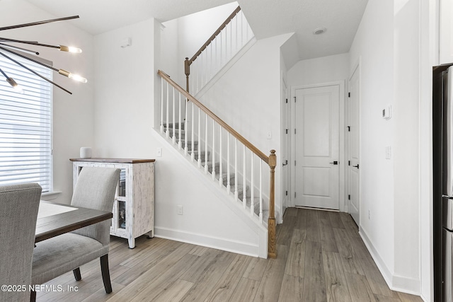 interior space with light wood finished floors, stairs, and baseboards