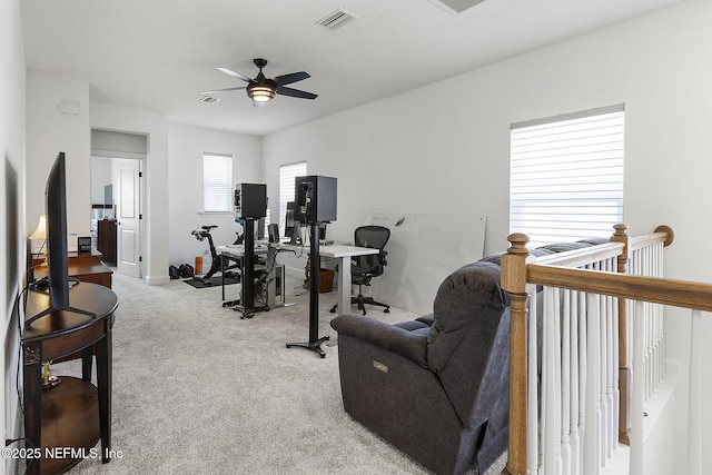 workout area featuring light colored carpet, ceiling fan, and visible vents