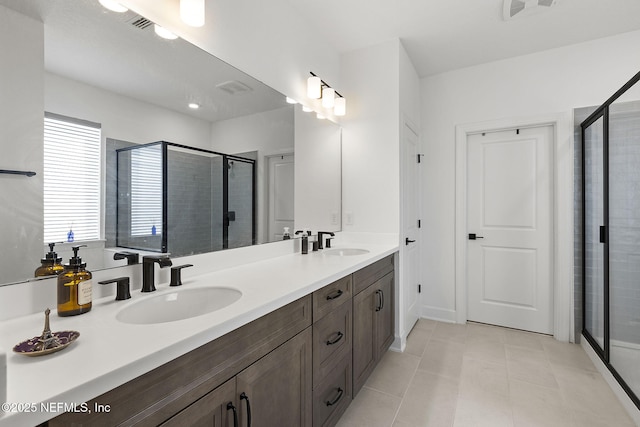 bathroom with double vanity, tile patterned flooring, a sink, and a shower stall