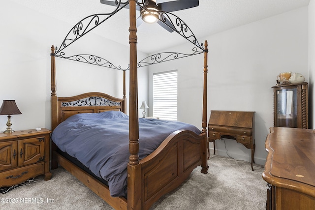 bedroom with a ceiling fan, light carpet, and a textured ceiling