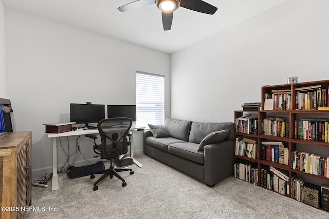 carpeted office with ceiling fan and baseboards