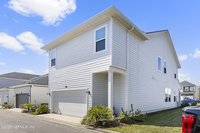 view of home's exterior with a garage, concrete driveway, and a yard