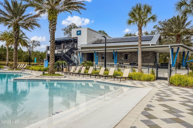 pool with a patio area and fence