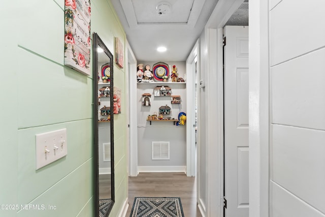 corridor with visible vents and wood finished floors