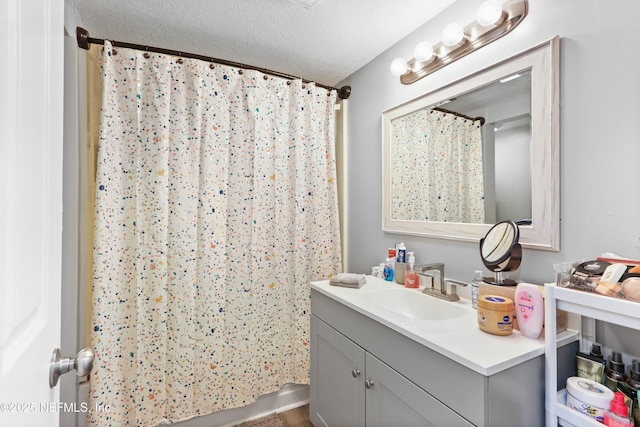 bathroom featuring a shower with curtain, a textured ceiling, and vanity