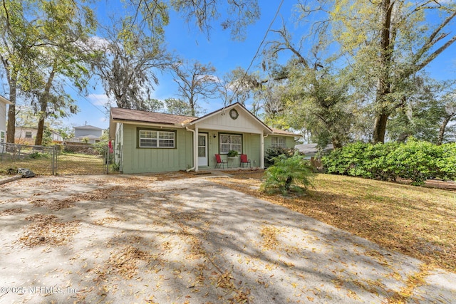 view of front of property with a gate, covered porch, driveway, and fence