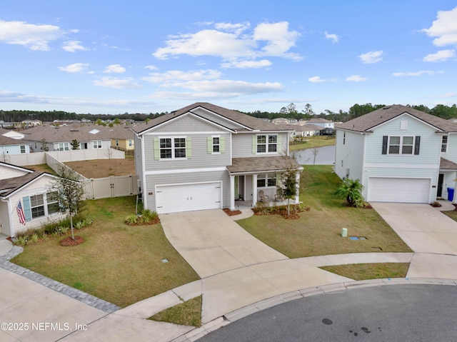 traditional-style home with a garage, driveway, a residential view, fence, and a front yard