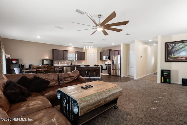 living area featuring recessed lighting, visible vents, dark carpet, a ceiling fan, and baseboards