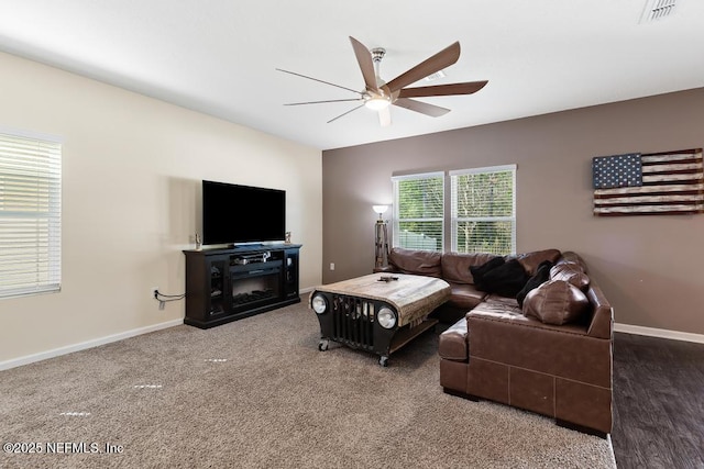 carpeted living area featuring ceiling fan, visible vents, and baseboards