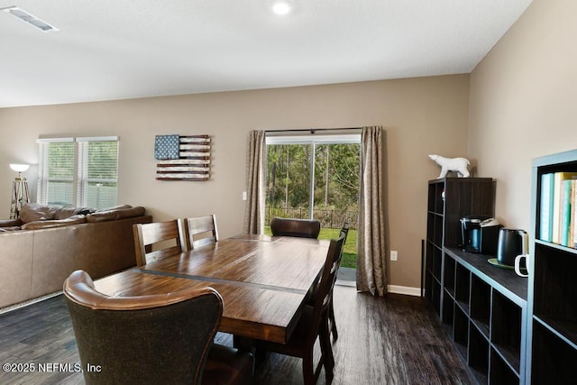 dining space with dark wood-type flooring, visible vents, and baseboards