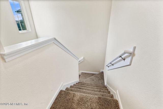 stairs featuring carpet flooring and baseboards