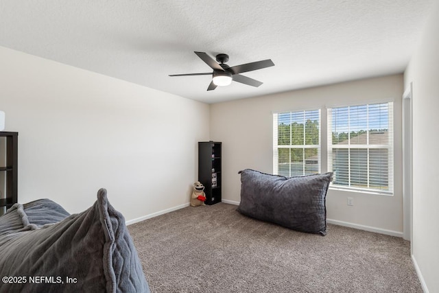 carpeted bedroom with a textured ceiling, baseboards, and a ceiling fan