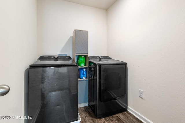 washroom featuring laundry area, baseboards, washer and clothes dryer, and dark wood-style flooring