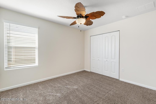 unfurnished bedroom featuring carpet floors, baseboards, visible vents, and a closet