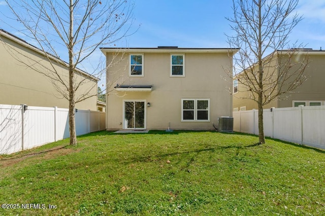 rear view of property with a lawn, cooling unit, a fenced backyard, and stucco siding