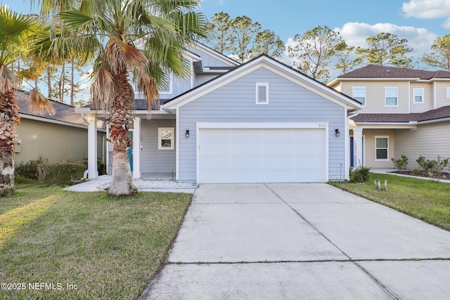 traditional-style house with a garage, a front yard, and driveway