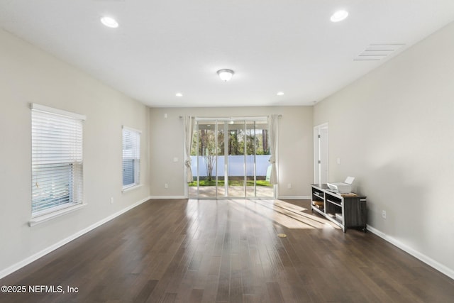 unfurnished living room with dark wood-style floors, recessed lighting, visible vents, and baseboards