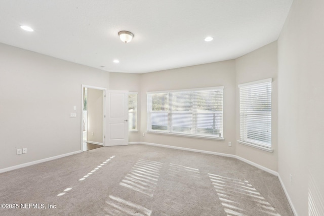 carpeted spare room featuring baseboards and recessed lighting