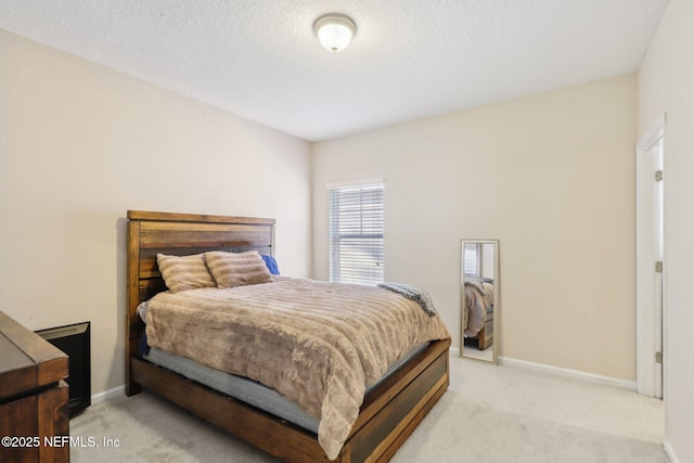 carpeted bedroom featuring a textured ceiling and baseboards