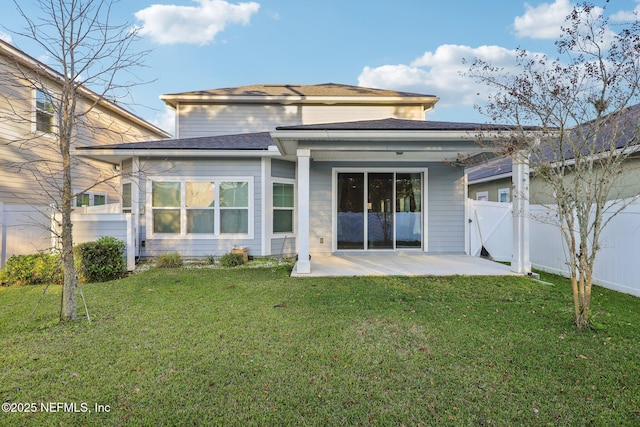 back of house with a patio area, a gate, fence, and a lawn