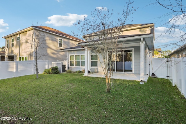 back of house with a yard, a patio area, a fenced backyard, and a gate