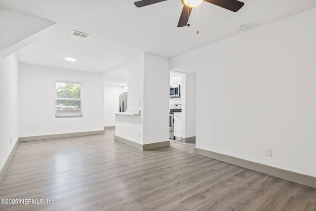 unfurnished living room featuring baseboards, a ceiling fan, visible vents, and light wood-style floors