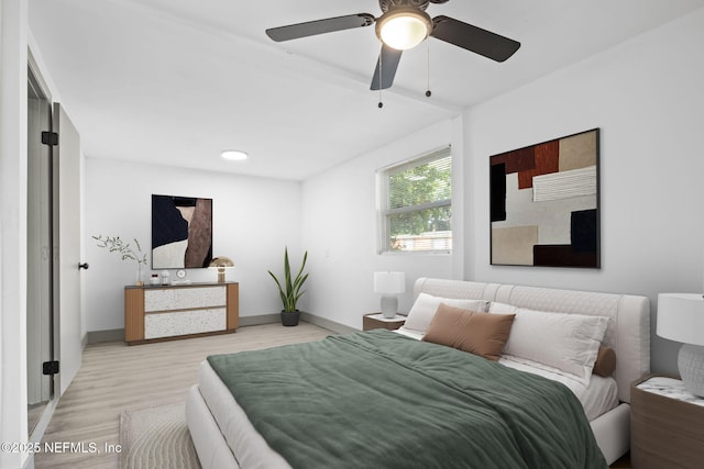 bedroom featuring light wood-type flooring, baseboards, and a ceiling fan