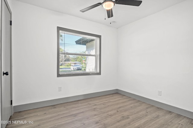 empty room with ceiling fan, baseboards, and wood finished floors