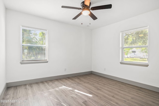 unfurnished room featuring wood finished floors, a ceiling fan, and baseboards