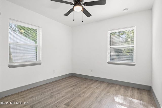 empty room featuring a ceiling fan, light wood-style flooring, and baseboards