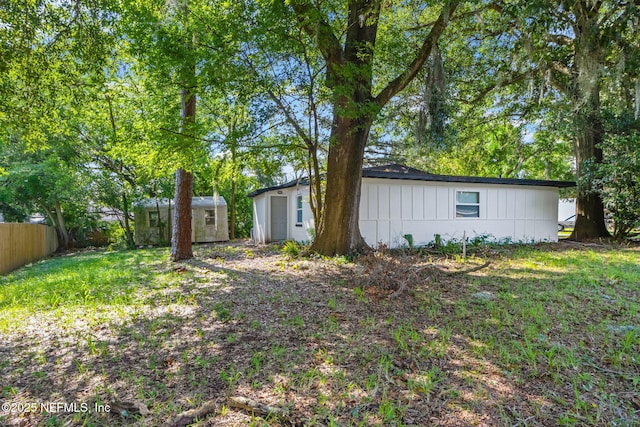 exterior space featuring an outbuilding, a shed, and fence