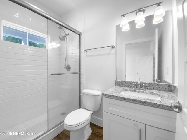 full bathroom with a shower stall, toilet, and vanity