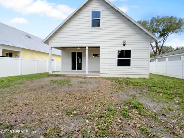 rear view of house with a fenced backyard and a patio