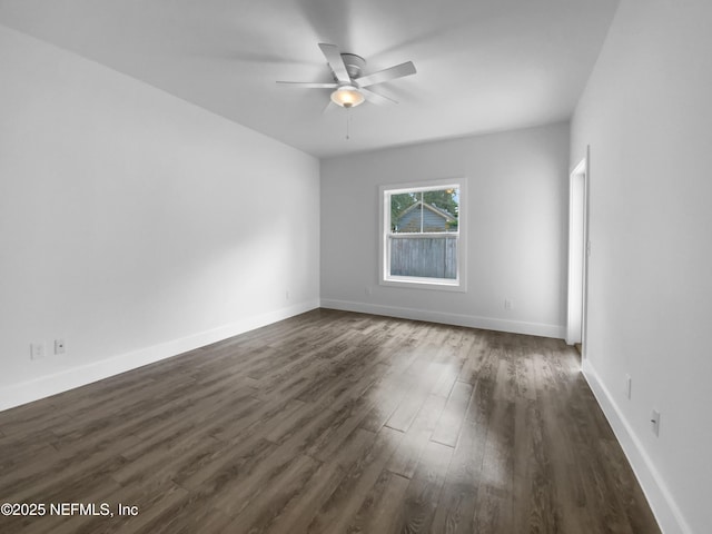 unfurnished room with ceiling fan, baseboards, and dark wood finished floors