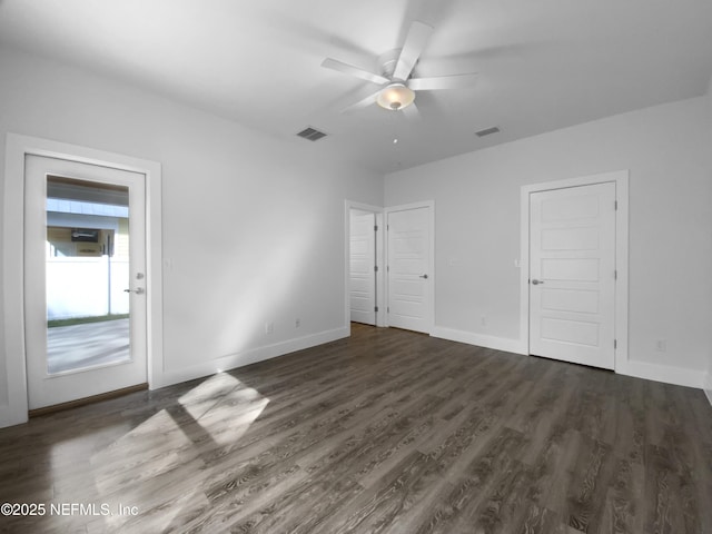 unfurnished bedroom featuring ceiling fan, dark wood-style flooring, visible vents, and baseboards