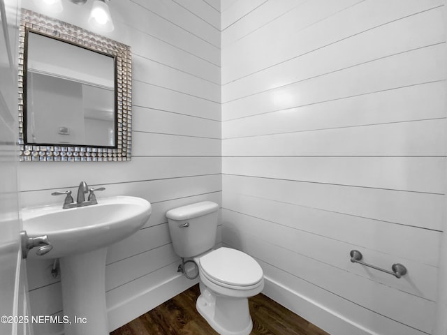 bathroom featuring baseboards, a sink, toilet, and wood finished floors