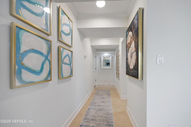 corridor featuring light tile patterned floors, baseboards, and crown molding