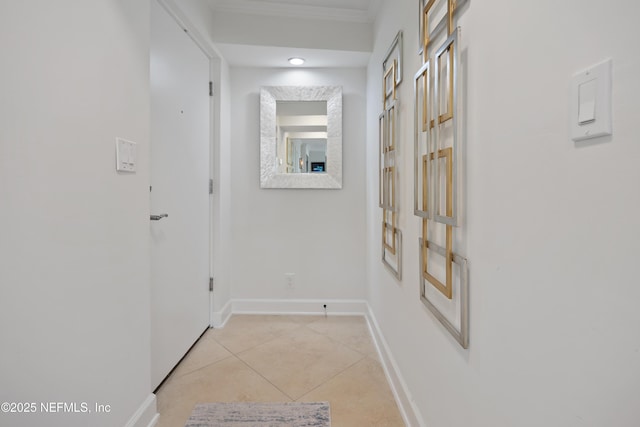 hall featuring baseboards and light tile patterned floors