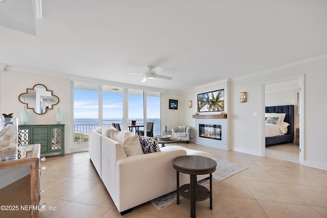 living area with light tile patterned floors, a wall of windows, a water view, and crown molding