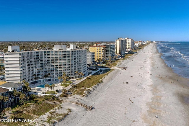 drone / aerial view featuring a view of the beach, a water view, and a city view