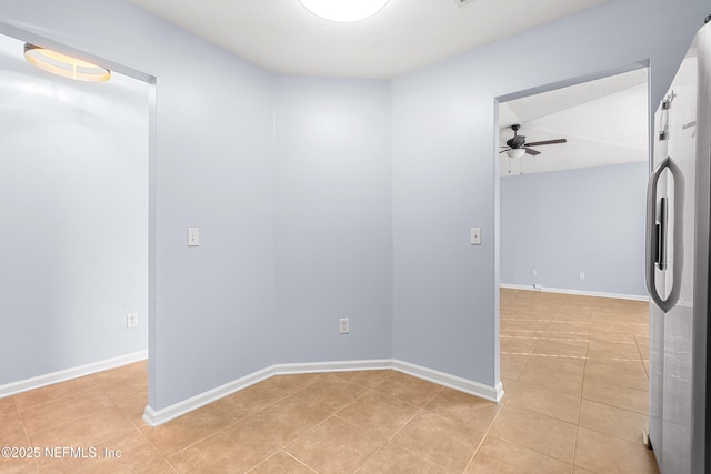 unfurnished room featuring light tile patterned floors, baseboards, and a ceiling fan