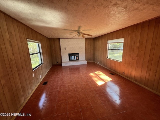 unfurnished living room featuring a fireplace, visible vents, and a textured ceiling