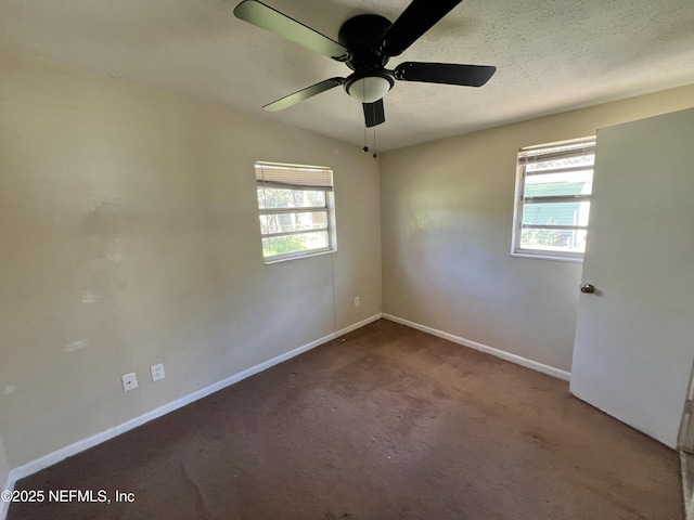 empty room with plenty of natural light, baseboards, a textured ceiling, and carpet flooring