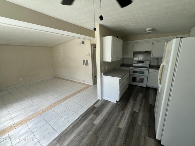 kitchen featuring a textured ceiling, white appliances, visible vents, backsplash, and dark wood finished floors