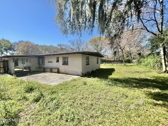 rear view of property with a yard, a patio, and fence