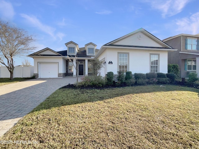 view of front facade with a garage, a front yard, decorative driveway, and stucco siding