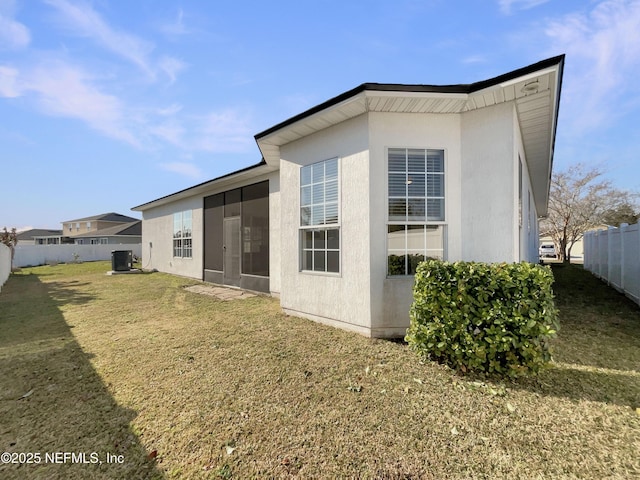 back of house featuring a lawn, fence, and central air condition unit