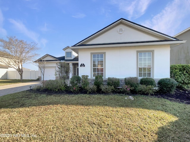 single story home featuring stucco siding, an attached garage, stone siding, driveway, and a front lawn